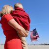 A Navy spouse and child wait expectantly for their husband and father.